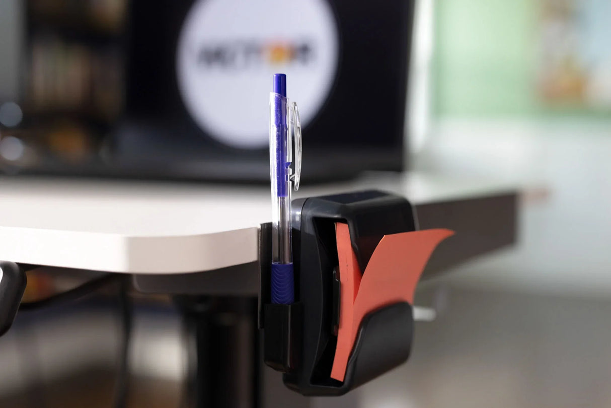 Desk edge organizer holding a blue pen and orange sticky notes in an office setting