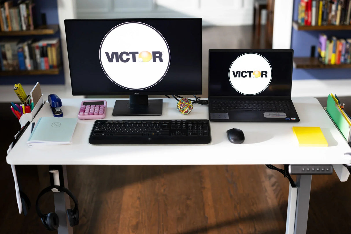 Modern standing desk with dual monitors, office supplies, organizers, and keyboard in workspace