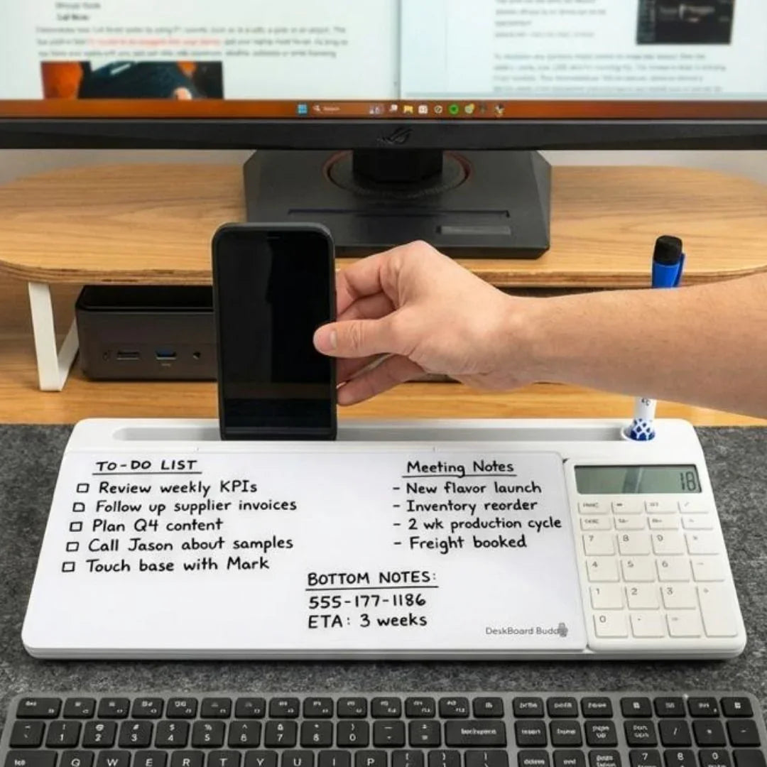 Desktop whiteboard organizer with integrated calculator, smartphone holder, and to-do list notes, placed in front of a computer monitor and keyboard, ideal for office productivity.