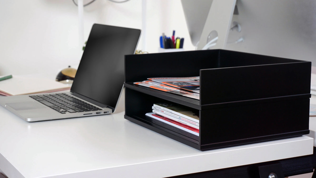Victor® black stacking letter tray desk organizer holding papers next to a laptop