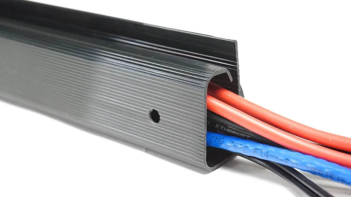 Close-up of red and blue cables inside a black Officemate magnetic cable raceway