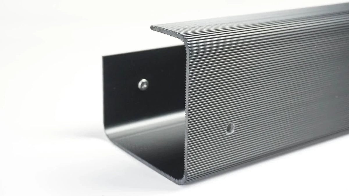 Close-up of a black ribbed Officemate® MagnetPlus Magnetic Cable Tray for workspace organization.