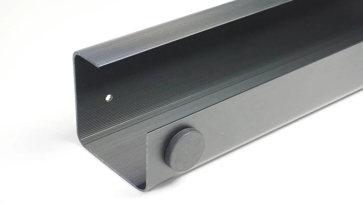 Close-up of a black Officemate MagnetPlus magnetic cable tray for workspace cable management.