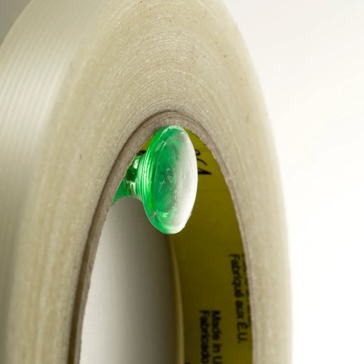 Clear packing tape roll with green dispenser, ideal for office and school use