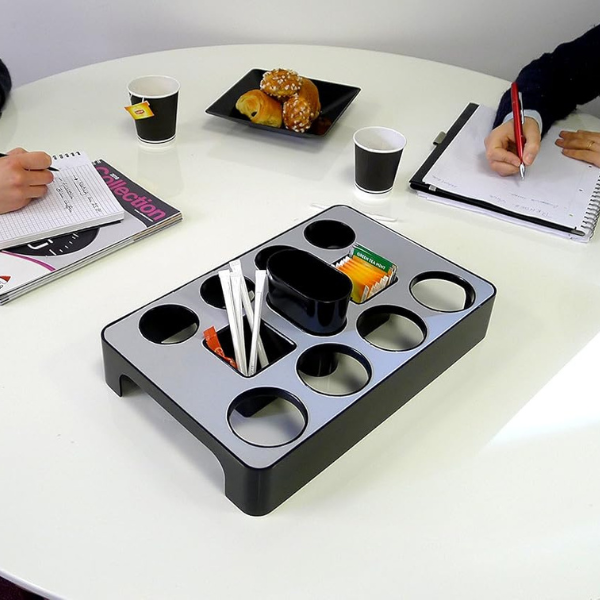 Aluminum grey and black universal capsules dispenser on meeting table with coffee supplies