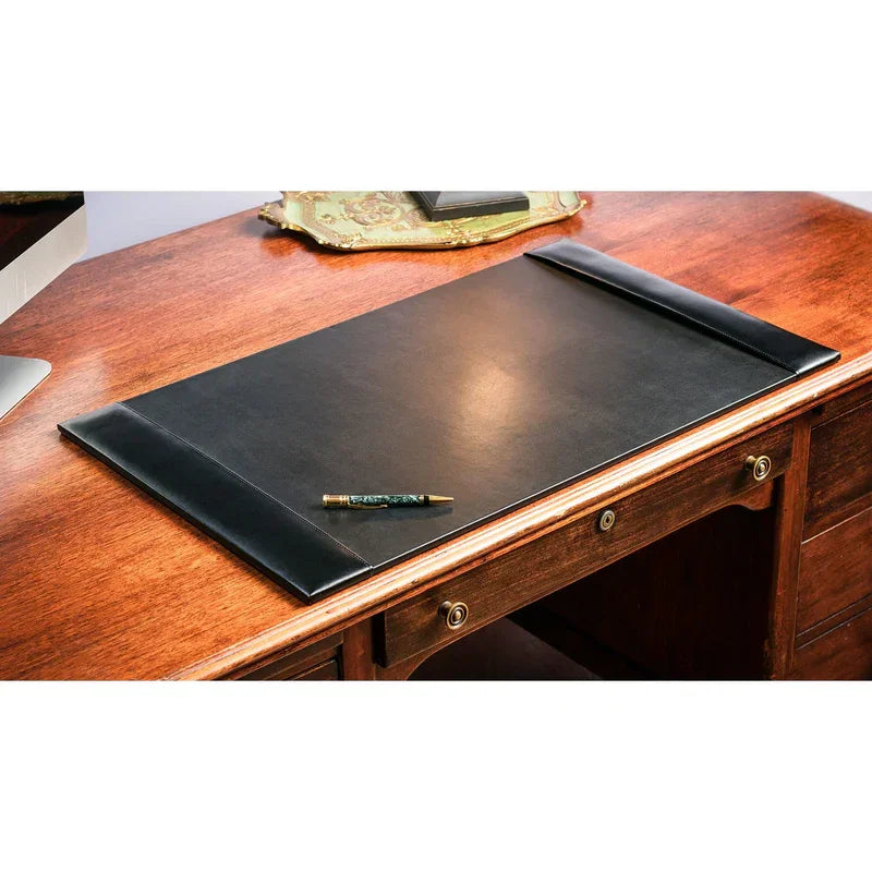 Black bonded leather desk pad on wooden desk with pen, office workspace accessory