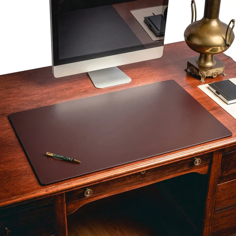 Black chocolate brown leather desk mat on wooden desk with computer and lamp