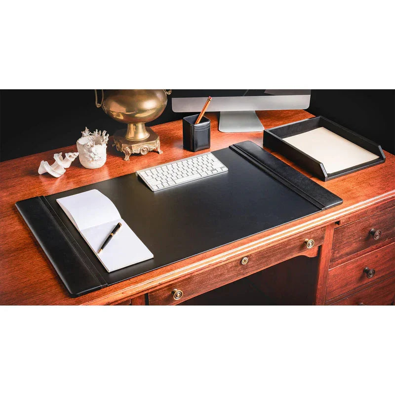 Black leather desk pad set with organizer and letter tray on a wood office desk