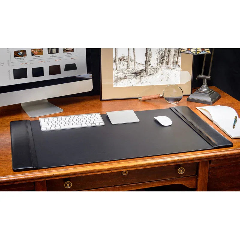 Black leather desk pad set on wood desk with computer keyboard, mouse, and office accessories