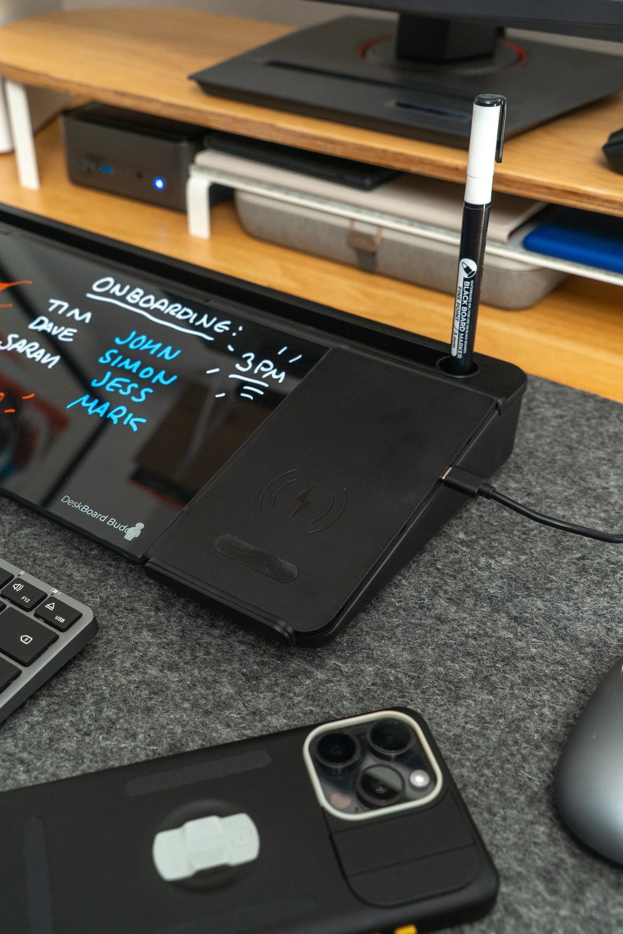 Desk organizer with wireless phone charger, dry erase glass board, and marker on an office desk