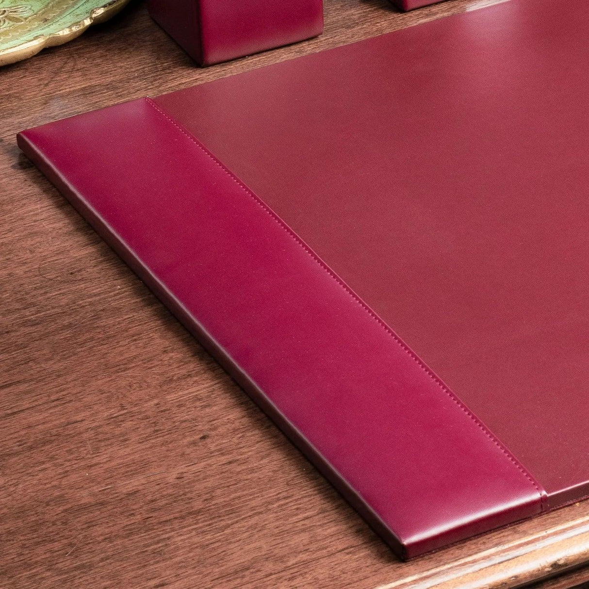 Burgundy bonded leather desk pad on wooden office desk, workspace organizer