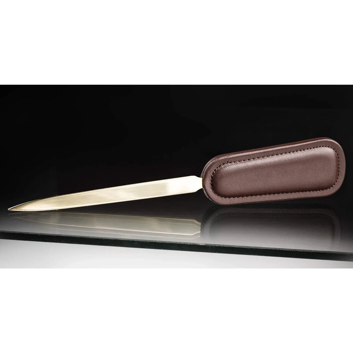 Chocolate brown leather letter opener with gold-toned blade on glass desk surface