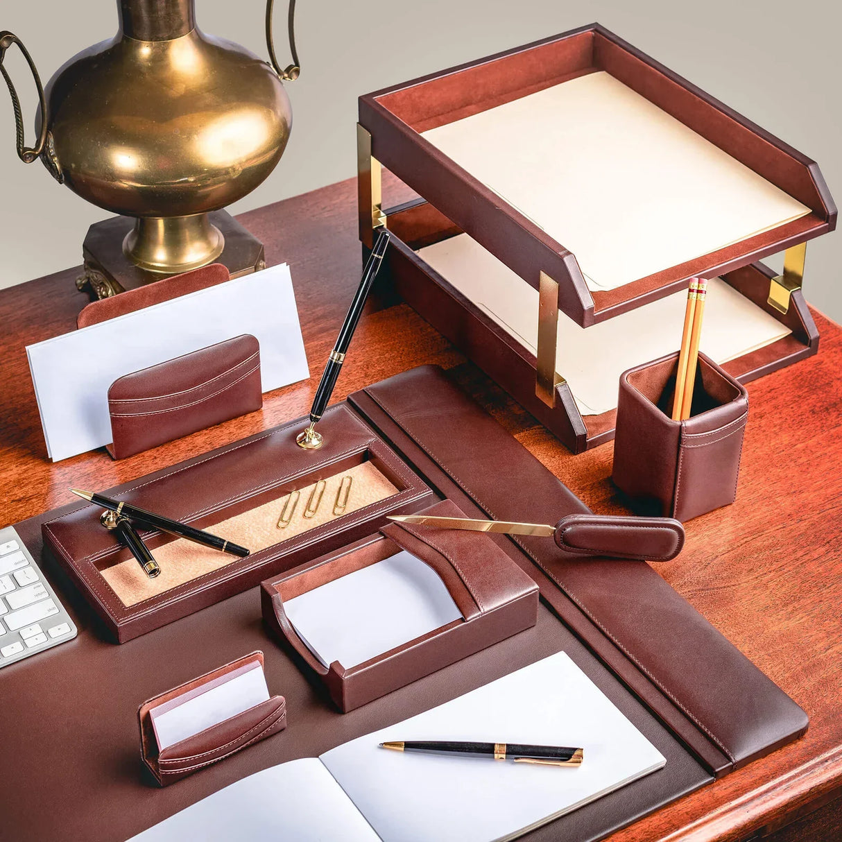 Chocolate brown leather desk organizer set with tray, pen holder, and accessories on wooden office desk