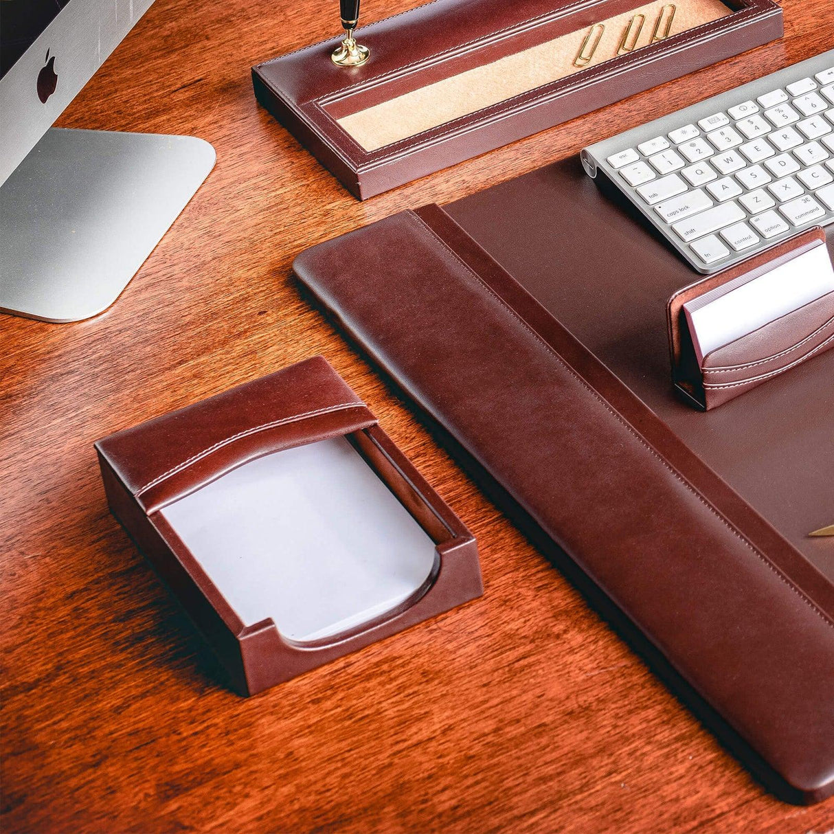 Chocolate brown leather desk set with organizer, pad, and card holder on wood desk
