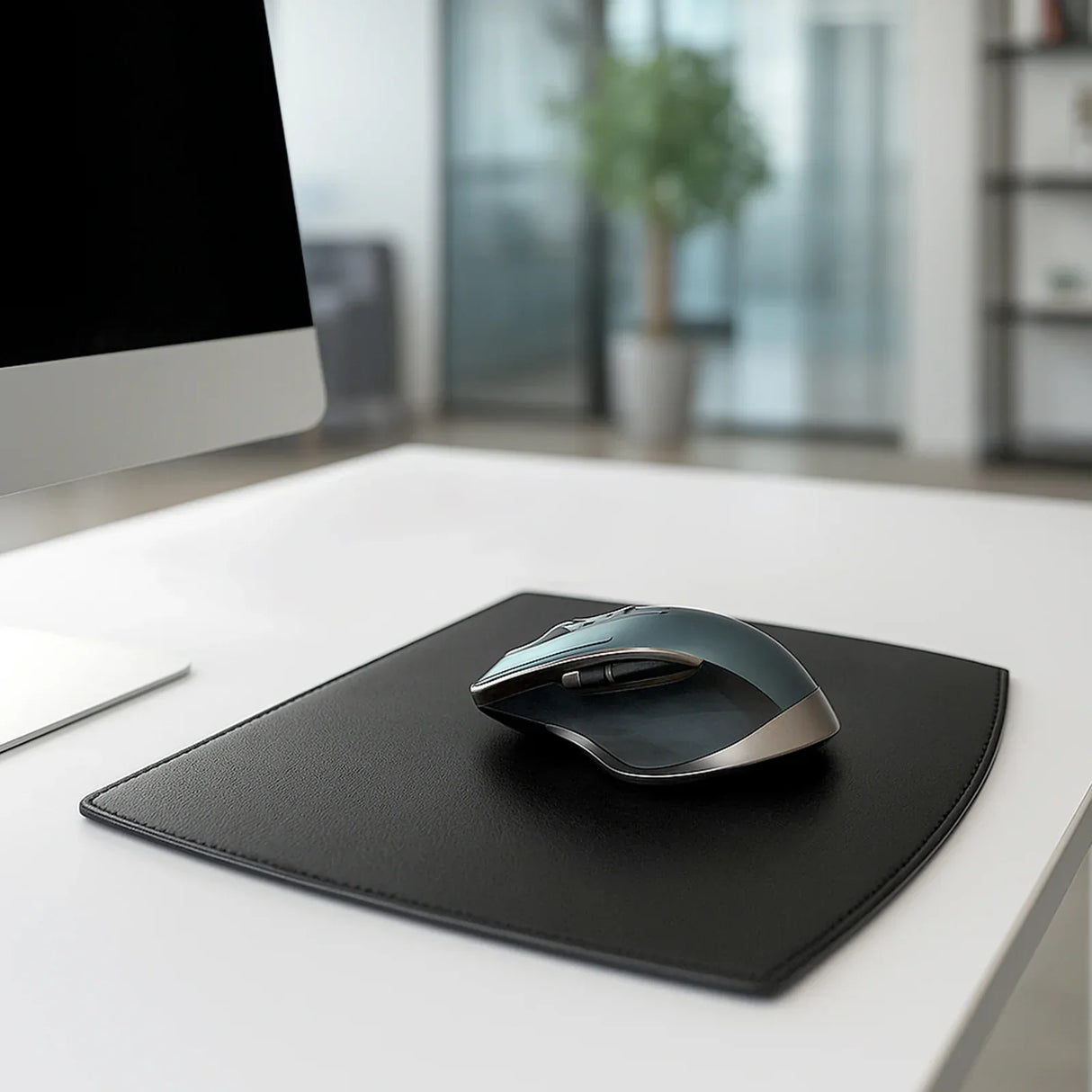 Black leather mouse pad with ergonomic mouse on white desk in modern office setting