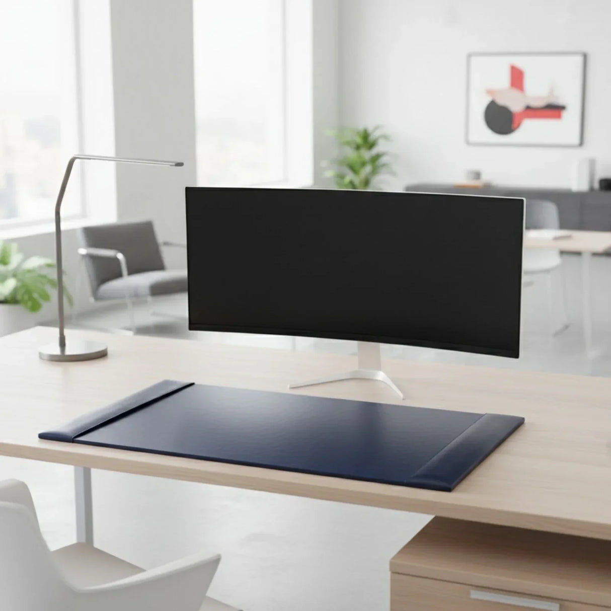Navy blue bonded leather desk pad on a modern office desk with monitor and lamp.