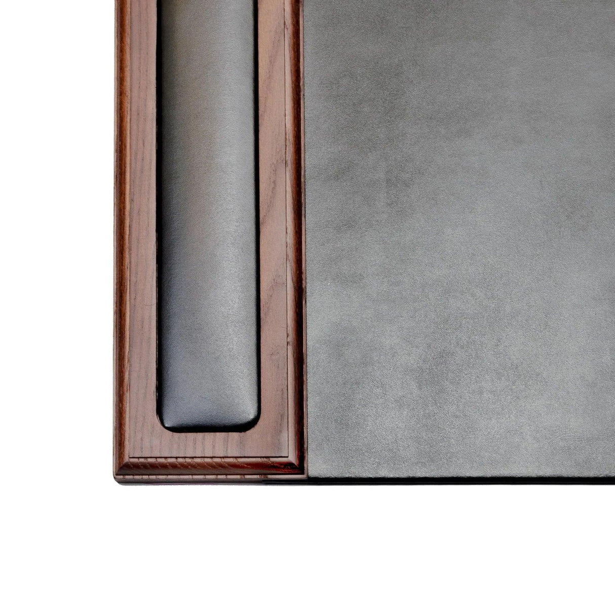 Corner of a walnut wood and black leather desk pad with side rail, close-up view.