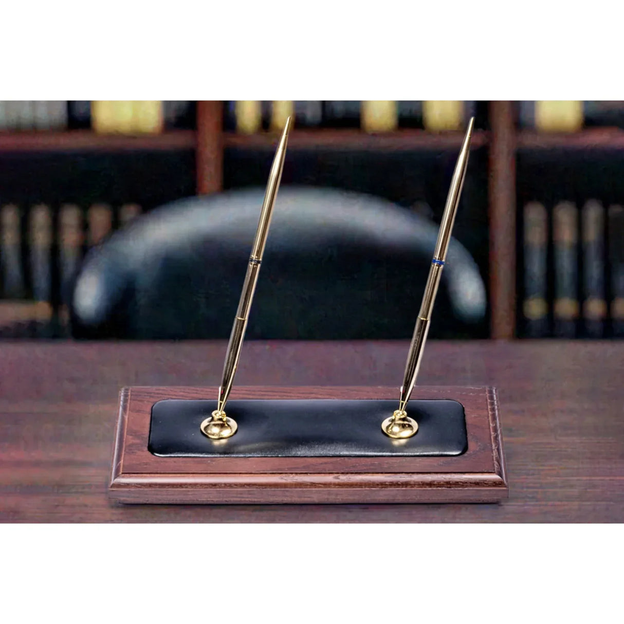Walnut and black leather double pen stand with two gold pens on office desk