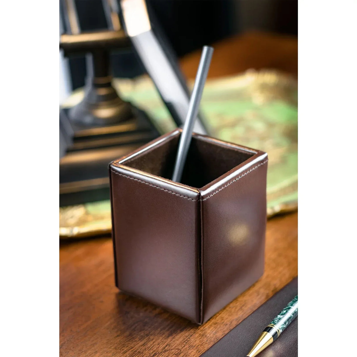 Dark brown bonded leather pencil cup on wooden desk with pen and office accessories