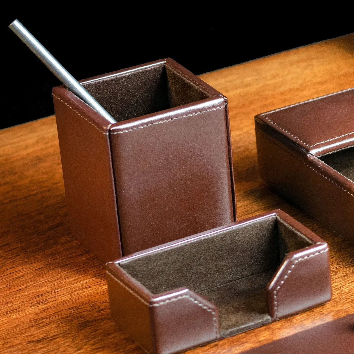 Dark brown bonded leather pencil cup on wooden desk with organizer trays, modern office decor