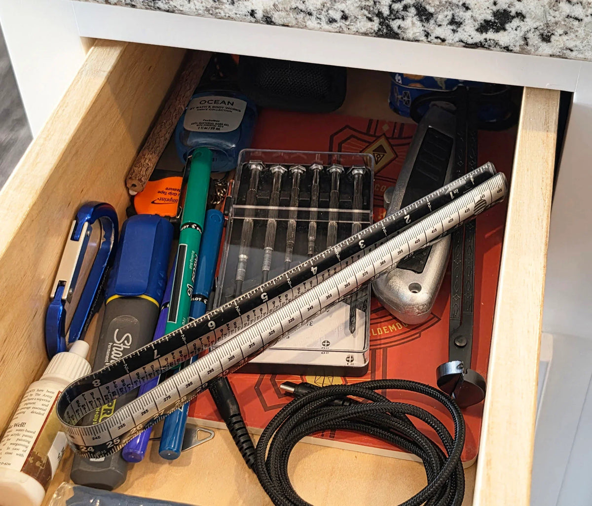 Victor® 18-inch magnetic ruler stored in a drawer with various office and tool supplies.