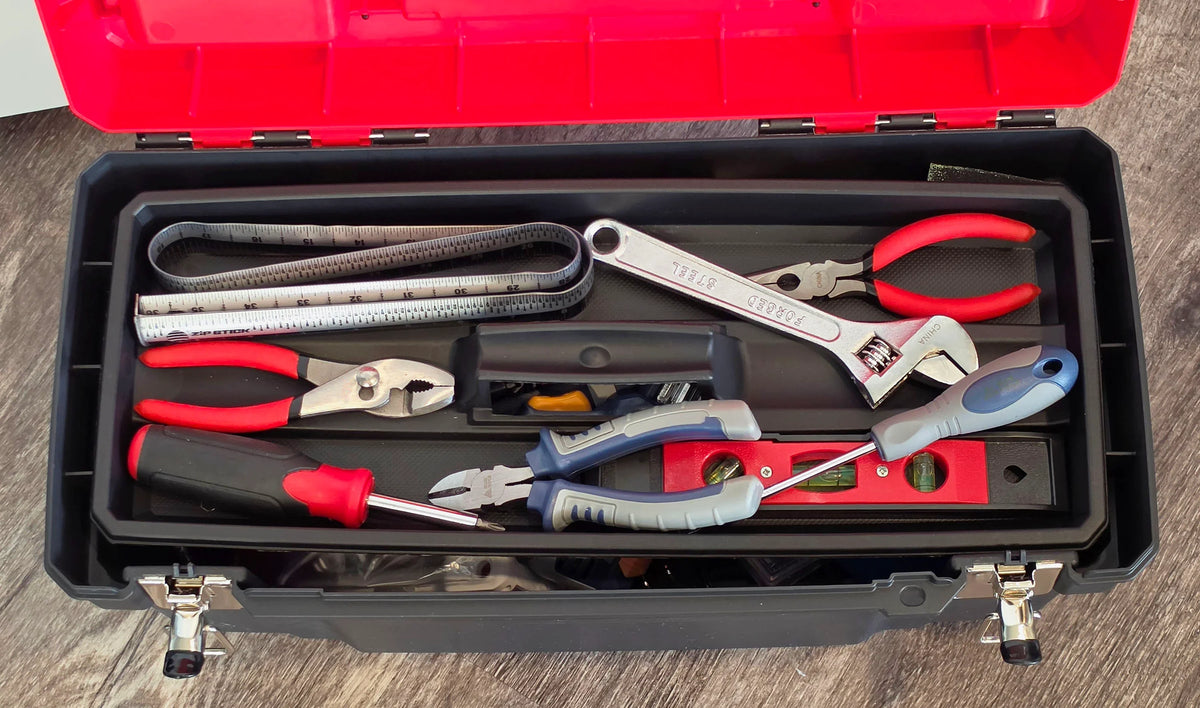 An open black toolbox filled with various hand tools including pliers, a wrench, and measuring tape.