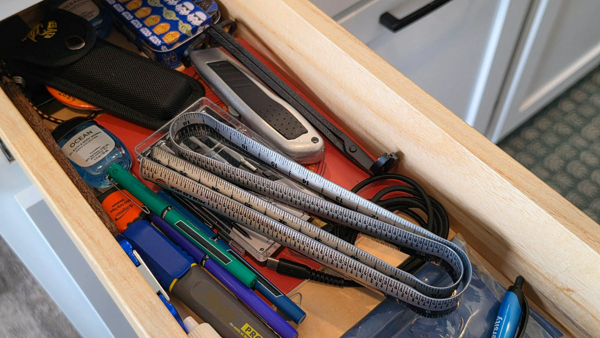 Victor® Zip Stick 36" magnetic ruler among office supplies in a wooden drawer.