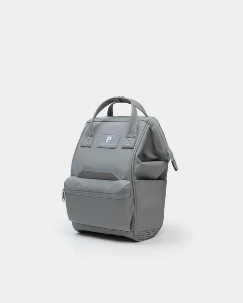 Grey compact backpack with front pocket and top handles on a plain background