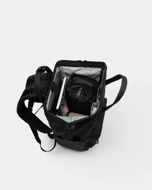 Black compact backpack with open top, organized interior holding books, bottle, and supplies