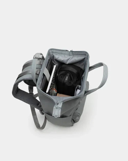 Open grey compact backpack with organized compartments, holding tablet and supplies