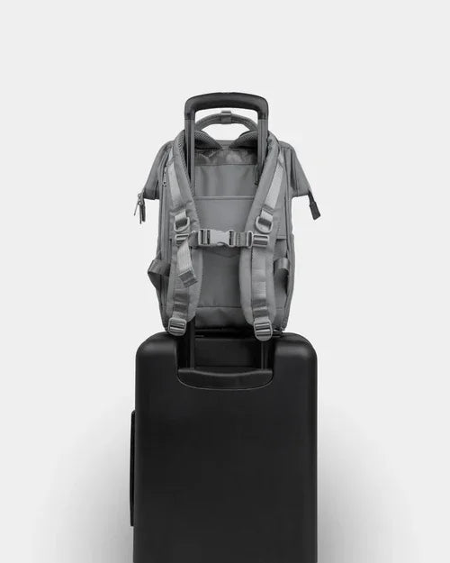Compact gray backpack securely attached to rolling suitcase, travel-friendly design shown