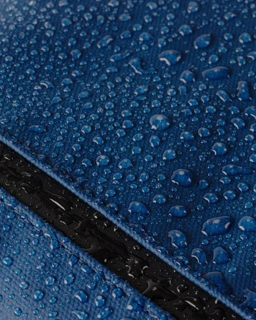 Blue waterproof fabric with water droplets, showcasing durable material for office or school gear