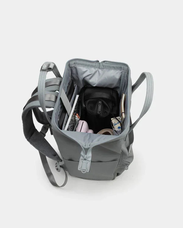 Gray backpack open with organized school supplies, notebooks, and tech gear inside for daily commute or office use.