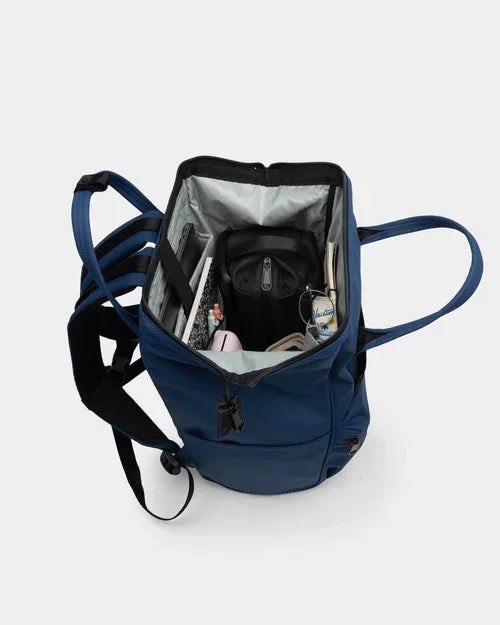 Navy blue backpack with organized interior, holding notebooks, water bottle, and school supplies for daily use.