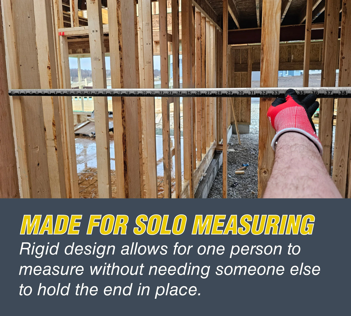 A person using a Victor ProSpan rigid measuring tool for solo measuring in a wood-frame building.