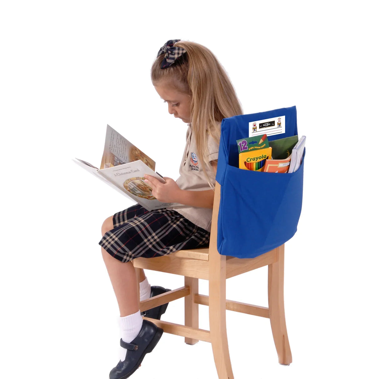 Child reading on chair with blue Seat Sack organizer filled with school supplies