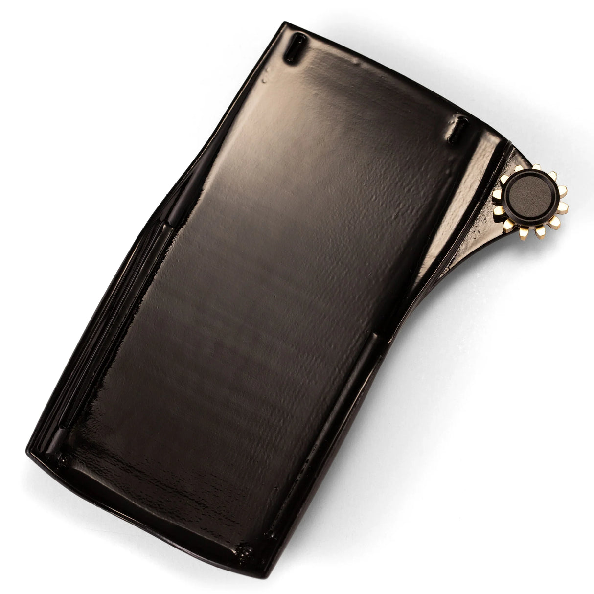 Black plastic calculator battery cover with gold gear dial on white background