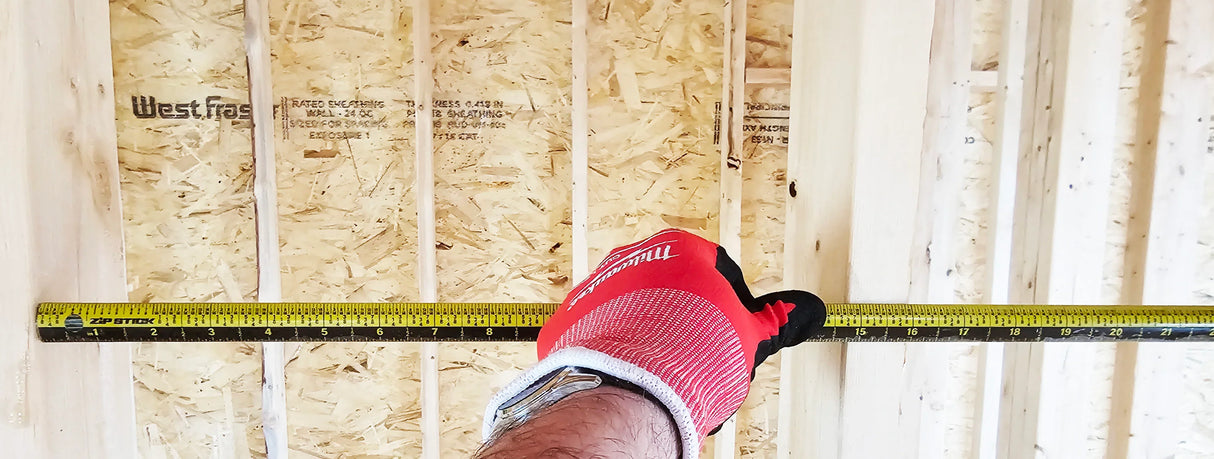 Hand wearing a red glove holding a ProSpan Zip Stick against wooden panels.