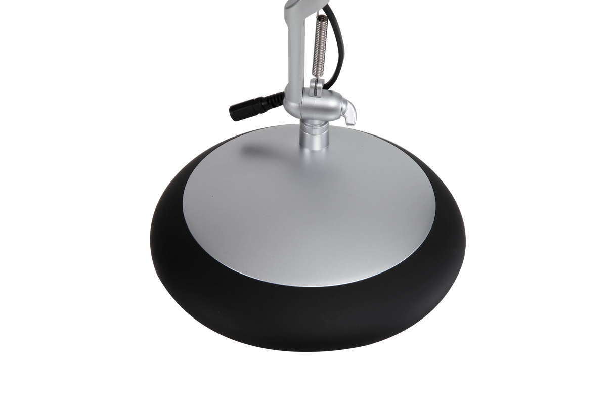 Black and silver round base of an LED desk lamp with adjustable arm attachment