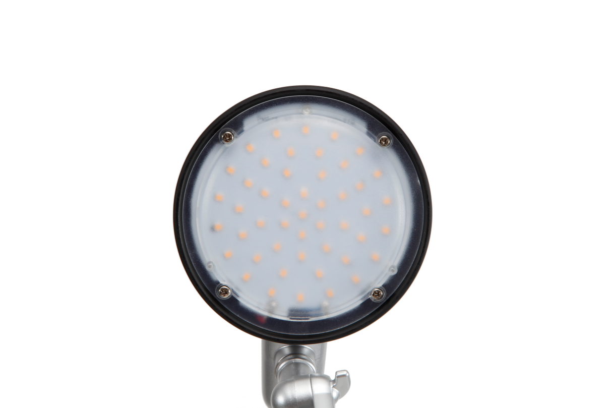 Close-up of round black LED desk lamp head with multiple LED lights, isolated on black