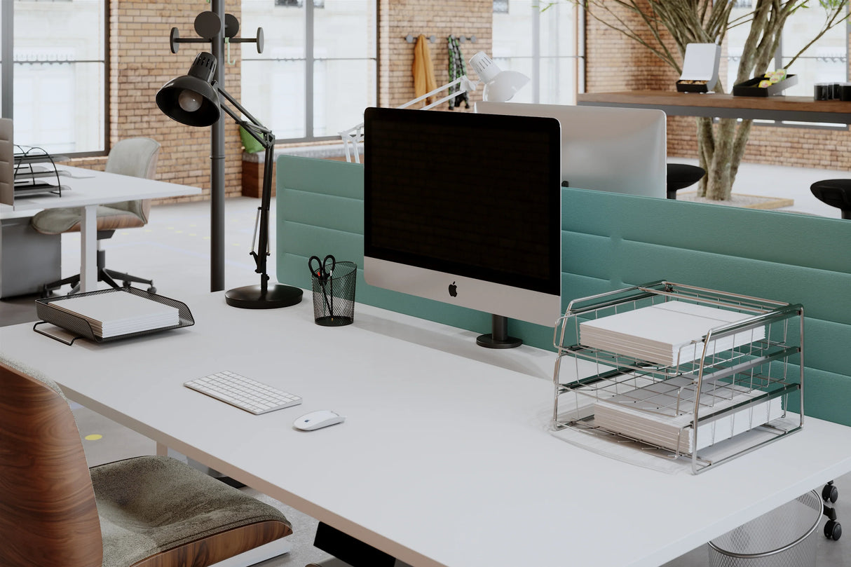 Three-tier chromed metal letter tray with paper on a modern office desk