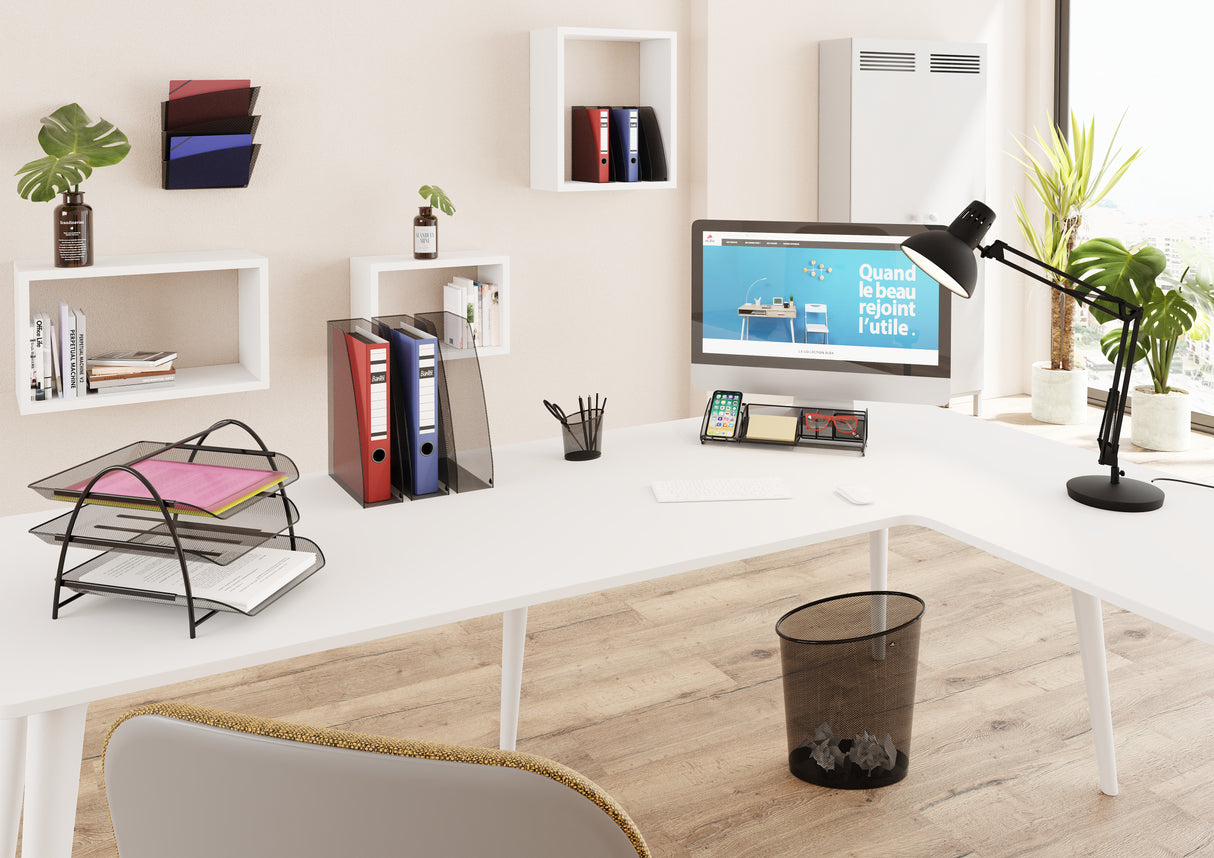 Mesh metal magazine holder in silver grey organizing binders on a modern office desk.