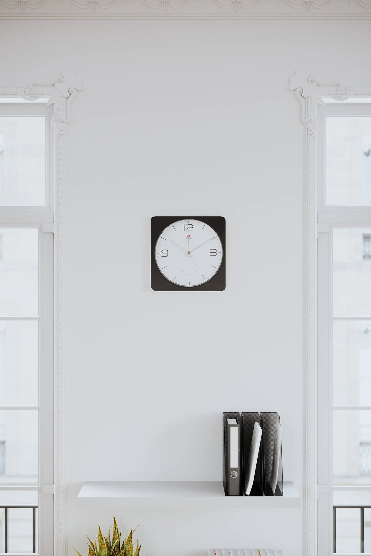 Modern office wall with black and white clock, shelf, and file organizers in natural light.