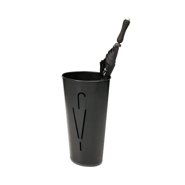 Black metal oval umbrella stand with modern cutout design holding a closed black umbrella