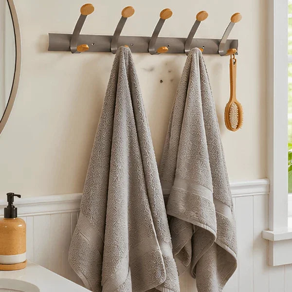 Alba wall mounted double peg rail with towels and a brush hanging in a bathroom