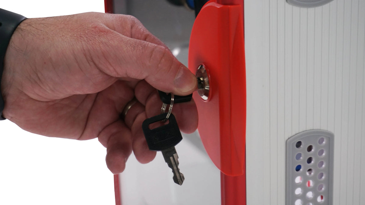 Hand locking a red and white cell phone locker with a key