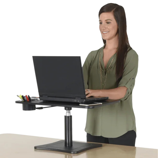 Woman using standing desk converter with laptop, ideal for ergonomic home office or workspace productivity.