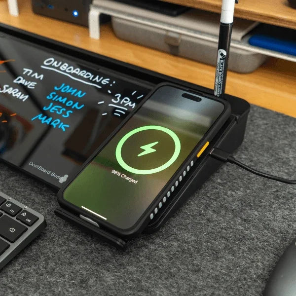 Wireless charging phone on desk with digital whiteboard and office tools