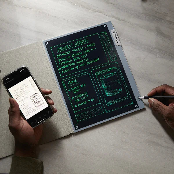Person writing on a smart digital notebook with notes, holding a smartphone nearby