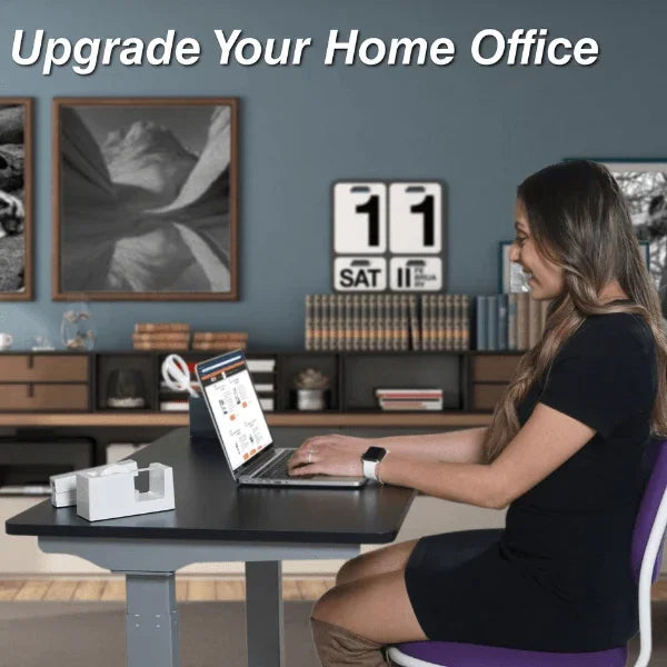 Woman using a laptop on a Victor® High Rise™ compact electric standing desk in a home office.